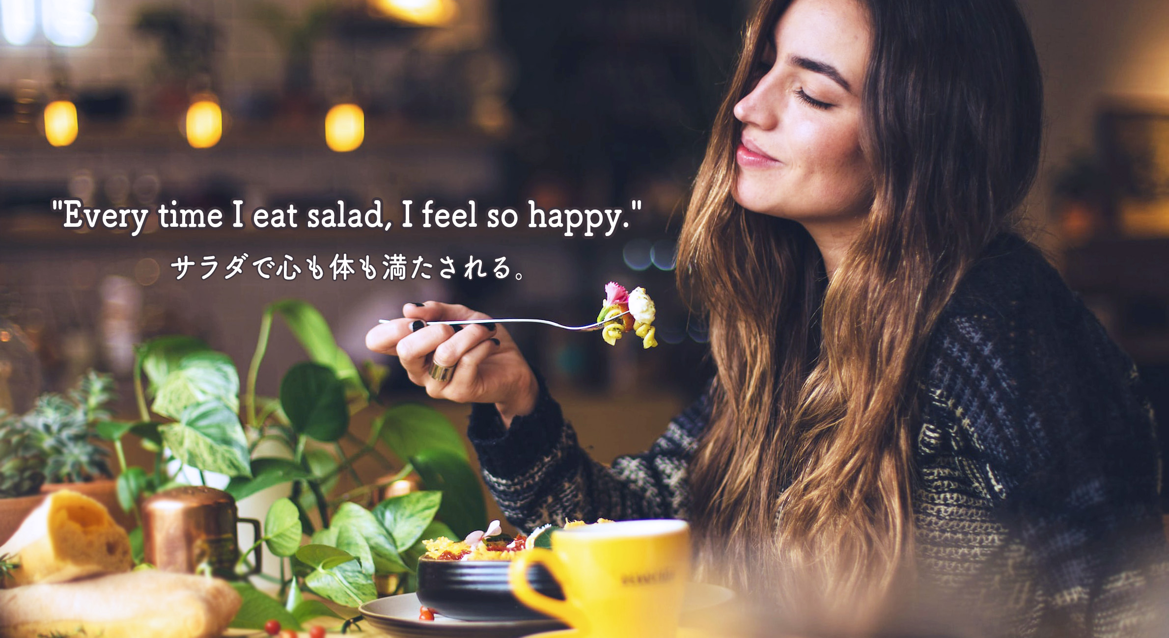 幸せそうにレストランでサラダを食べている女性の写真