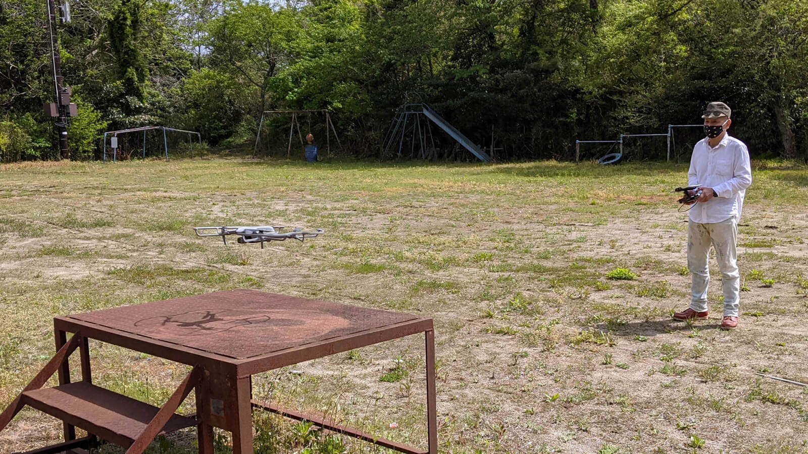 広い屋外のフィールドでドローンを飛ばす風景