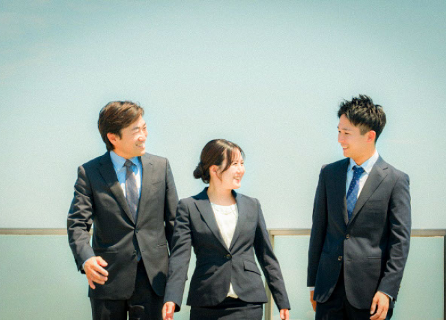 ３人の社員が微笑みあっている